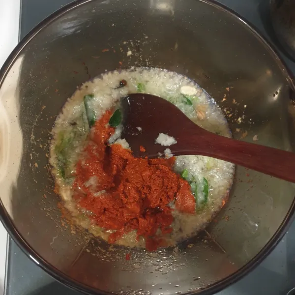 Masukkan bubuk kari dan cabai bubuk yang telah dilarutkan sebelumnya. Tumis hingga harum dan keluar minyak.