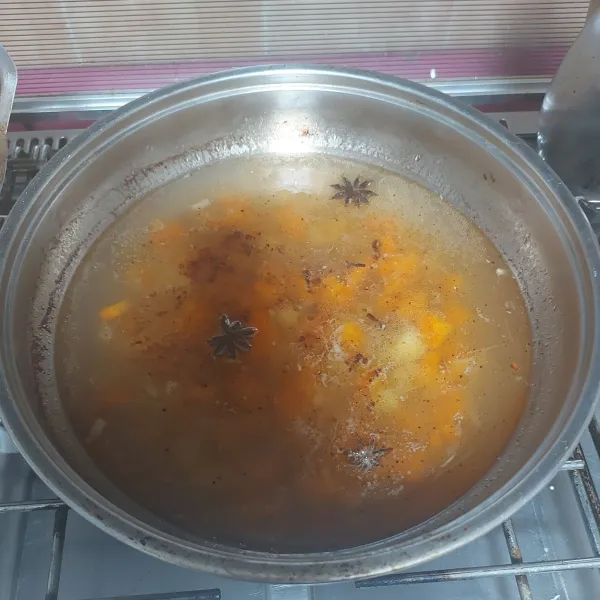Masukkan bumbu tumisan, potongan kentang wortel, bunga pekak, dan cengkeh.