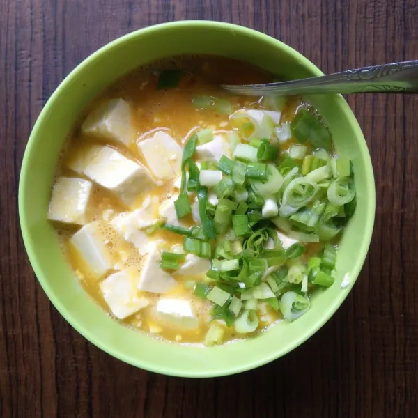 Masukkan tahu dan irisan daun bawang, aduk rata.