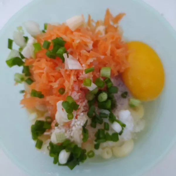 Masukkan makaroni rebus, wortel parut, irisan daun bawang, telur, garam, merica dan kaldu jamur. Aduk rata.