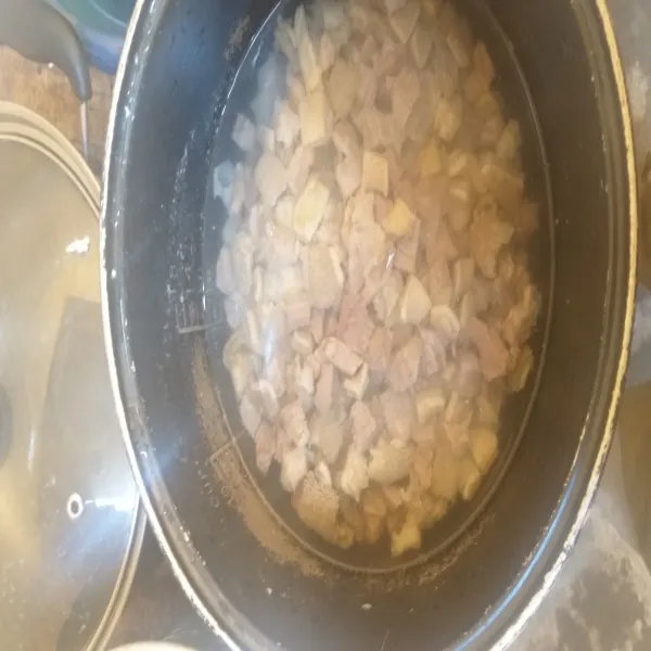 Rebus daging sampai mendidih kemudian buang busa rebusannya. Setelah matang, angkat dan tiriskan kemudian potong-potong