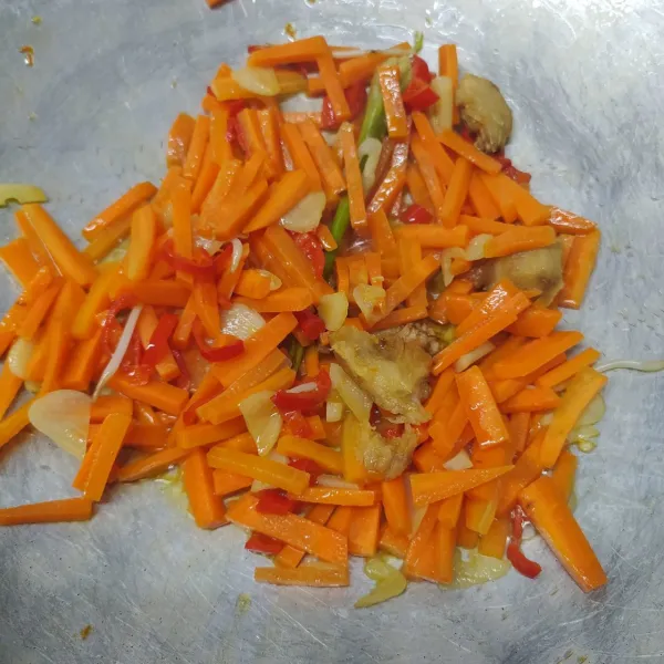 Masukkan irisan wortel, masak sampai setengah matang.
