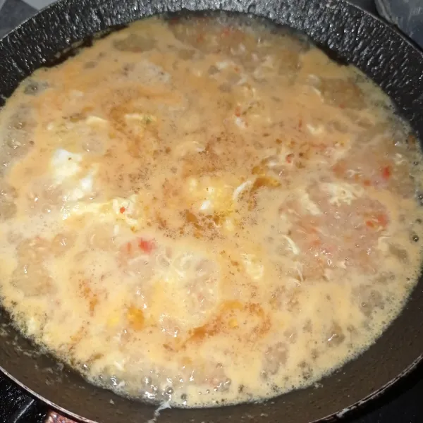 Masukkan telur buat orak-arik sampai matang, tuangi air masak sampai mendidih bumbui garam, gula pasir dan cabe bubuk, aduk rata.