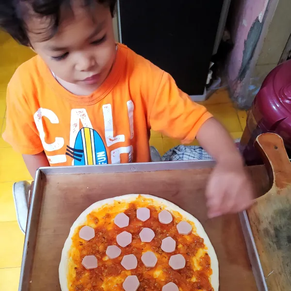 Tata irisan sosis di atasnya.