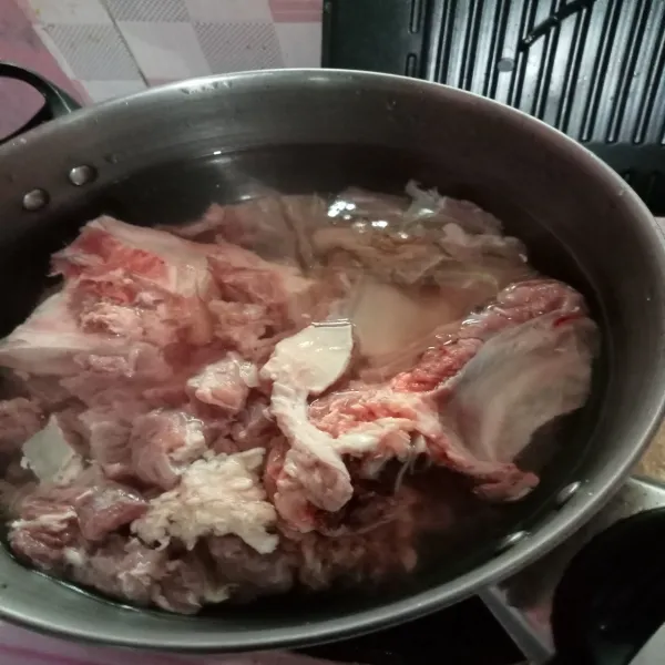 Rebus potongan daging dan tulang sapi sampai daging empuk