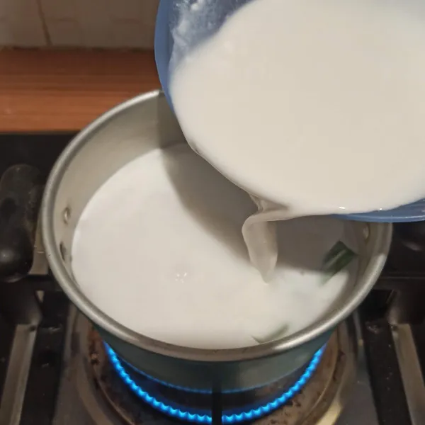 Setelah santan mendidih, tuang larutan tepung beras ke dalam panci.