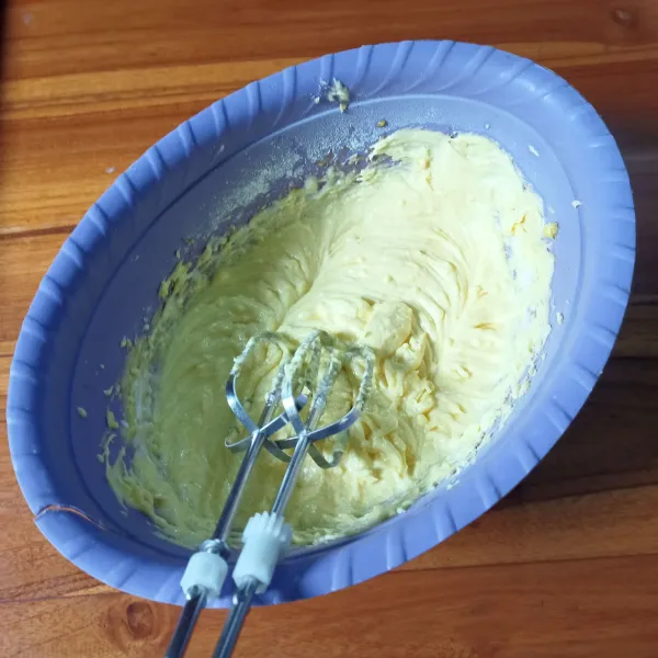 Kocok margarin dan gula 1 menit. Masukkan kuning telur dan santan. Kocok asal rata. Tambahkan keju parut, aduk rata.