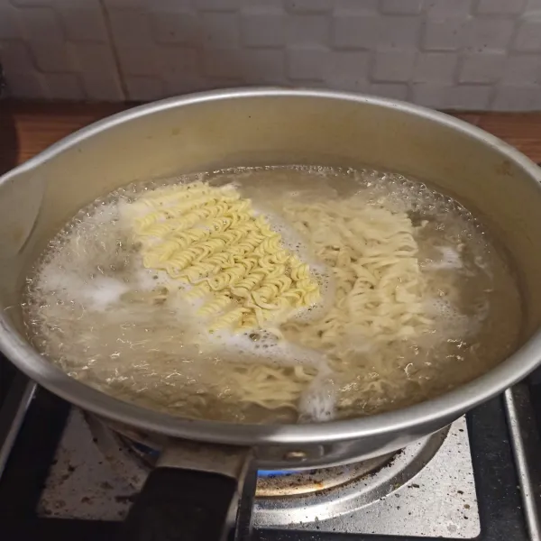 Rebus mie setengah matang, lalu tiriskan.