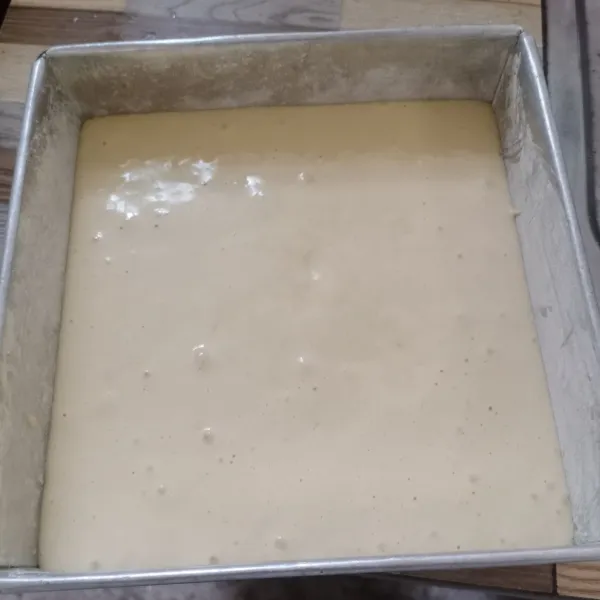 Masukkan adonan kedalam loyang yang sudah diolesi margarin dan ditaburi tepung terigu.