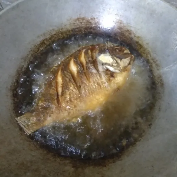 Selanjutnya panaskan minyak banyak, goreng ikan sampai matang kedua sisinya.