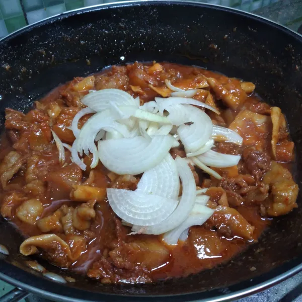 Tambahkan air dan masak hingga bumbu meresap. Masukkan bawang bombay dan aduk rata, masak sebentar.