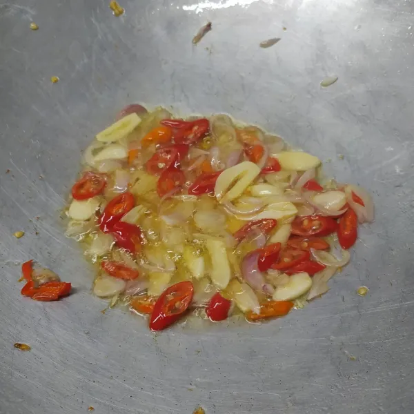 Tumis irisan bawang merah, bawang putih, cabe merah, dan cabai rawit sampai layu dan harum.