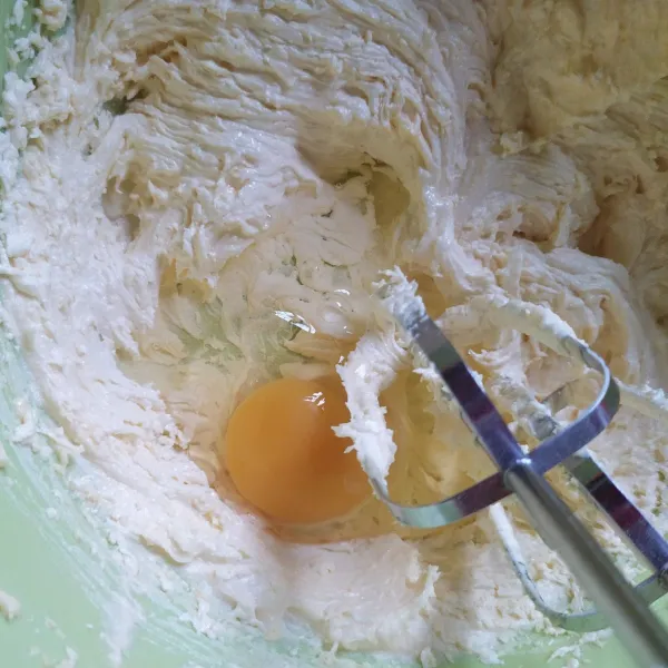 Kocok margarin, gula halus, dan vanilla essence hingga lembut. Tambahkan telur satu persatu, kocok hingga mengembang.