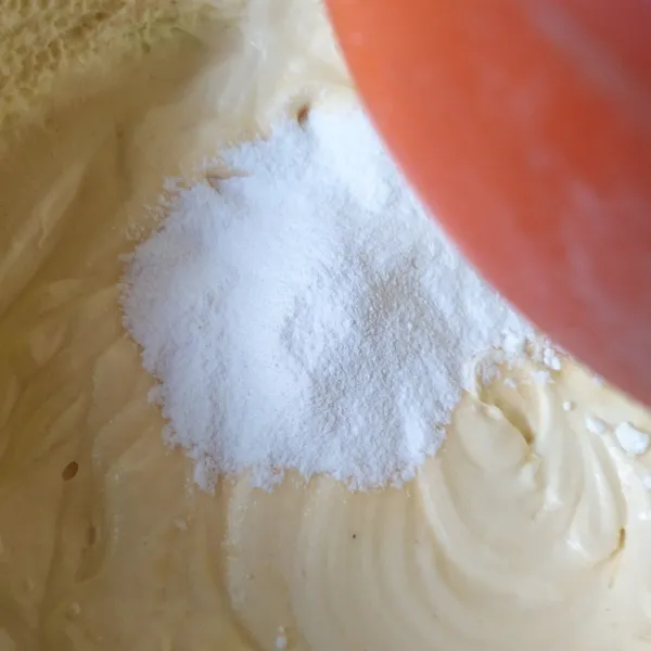 Campur tepung terigu, garam, baking powder, dan soda kue, ayak ke dalam adonan sedikit demi sedikit. Aduk dengan spatula hingga rata.