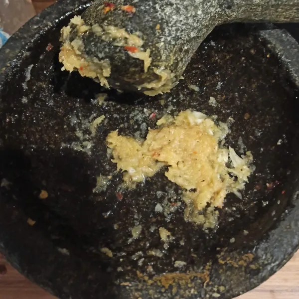 Haluskan bawang putih dan merica.