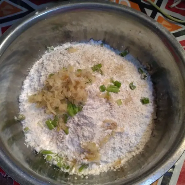 Masukkan bawang putih halus , daun bawang lalu beri sedikit-sedikit air panas. uleni hingga semua tercampur. Bagi menjadi 2 adonan untuk baso aci dan cuanki.