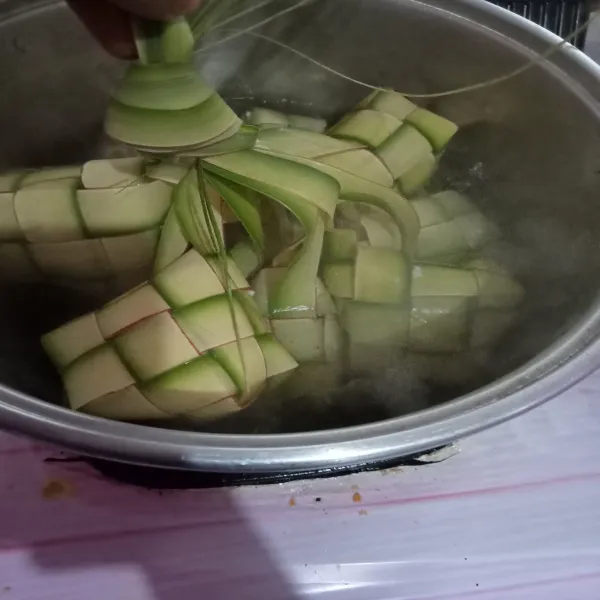 Masukkan ketupat sampai terendam air rebusan.
