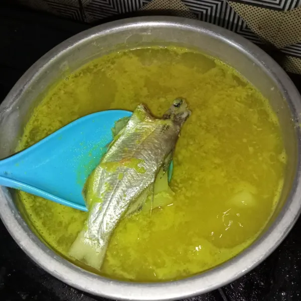 Masukkan ikan beserta bumbunya, lengkuas dan serai, aduk pelan.