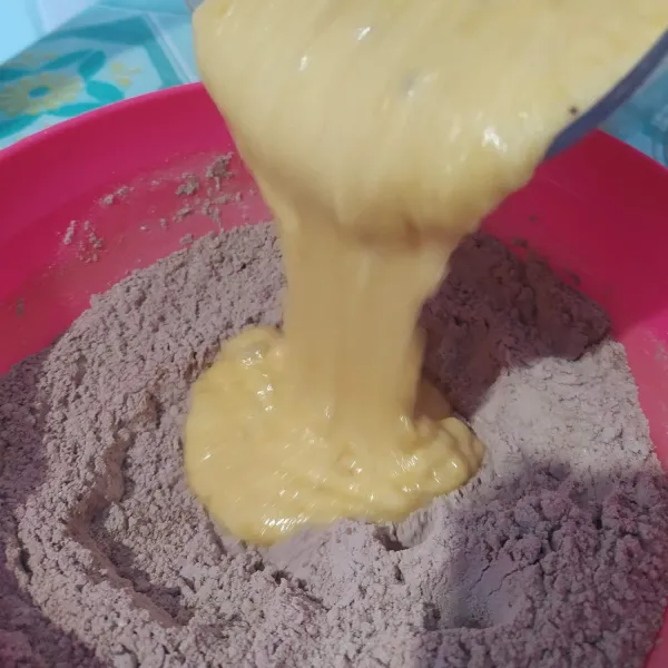 Buat lubang ditengah bahan tepung, tuang campuran pisang kedalamnya. Aduk rata sebenatar untuk sekedar mencampurkan bahan, jangan terlalu lama mengaduk agar muffin tidak keras nantinya.