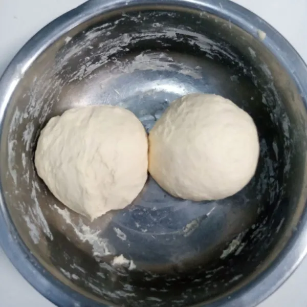 Setelah adonan didiamkan selama 1 jam dan telah mengembang, kempiskan adonan dengan diuleni kembali sambil ditekan dan pukul tinju agar udara dalam adonan keluar. Kemudian bagi menjadi dua bagian.