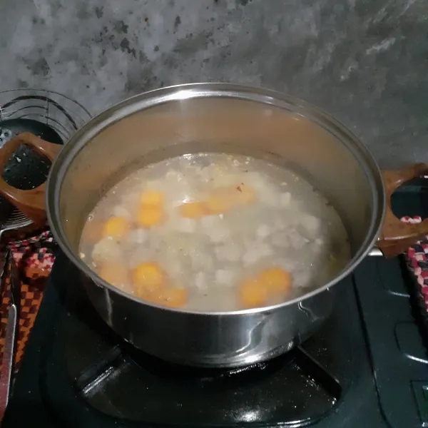 Didihkan air. Masukkan tetelan, wortel, dan bumbu yang sudah ditumis. Bumbui dengan garam, kaldu, gula, dan lada. Masak sampai wortel setengah matang.