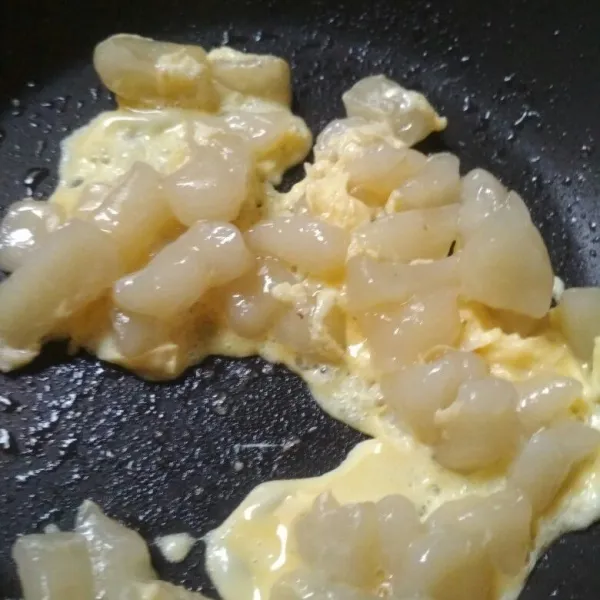 Panaskan minyak di teflon, masukkan adonan aci yang sudah direbus, tambahkan kocokan telur.