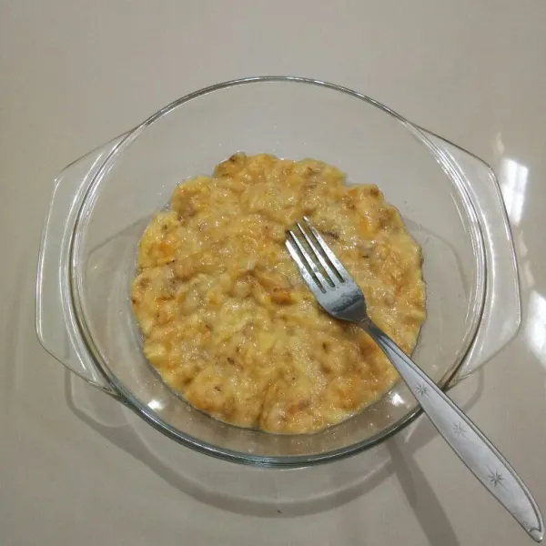 Kupas pisang, masukkan ke dalam mangkuk, lalu lumatkan dengan garpu.