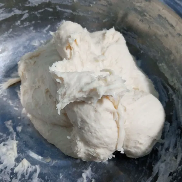 Buat adonan pizza terlebih dahulu dengan campurkan ragi instan, gula pasir, dan air hangat. Aduk rata dan diamkan sampai berbuih. Setelah berbuih, tuang biang ke dalam campuran tepung terigu dan garam. Uleni sampai setengah kalis.