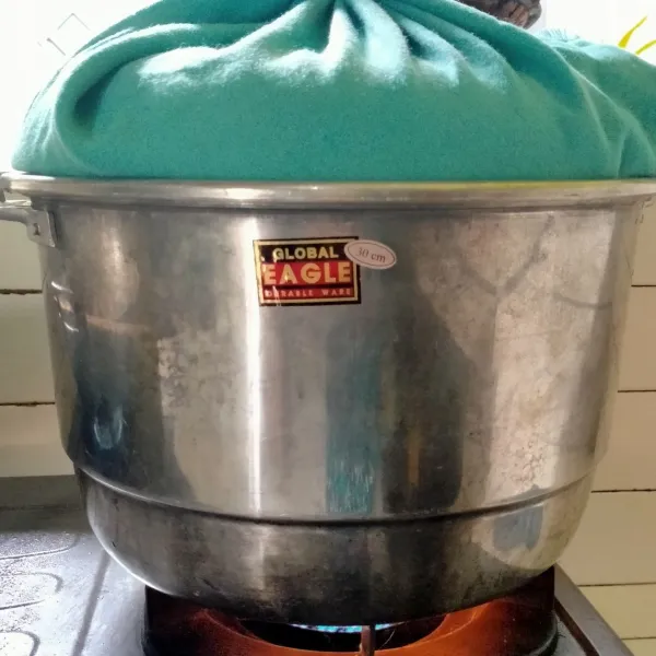 Lapisi tutup kukusan dengan kain, agar uap tidak menetes ke adonan. Kukus selama 20 menit, jangan buka tutup.