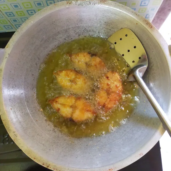 Siapkan wajan, panaskan minyak goreng dengan menggunakan api sedang lalu goreng ikan hingga kering, kemudian angkat dan tiriskan.
