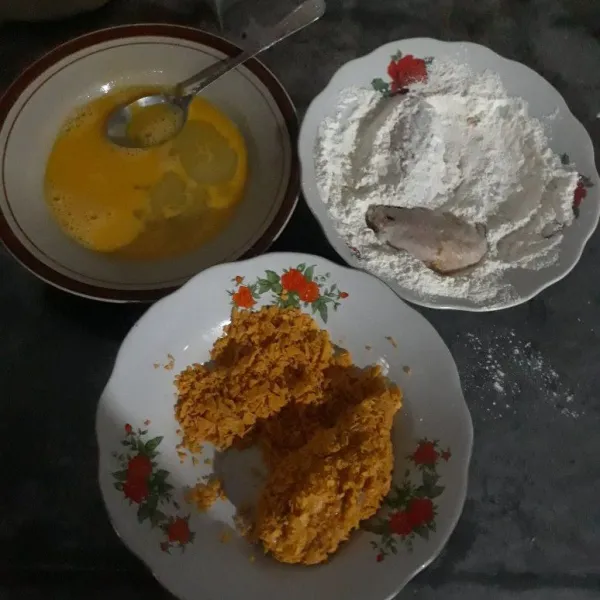 Siapkan tepung bumbu kemudian baluri sayap ayam dengan tepung bumbu, celupkan ke dalam kocokan telur, lalu gulingkan ke dalam snack Doritos hingga sayap ayam tertutupi dengan snack di seluruh sisi.