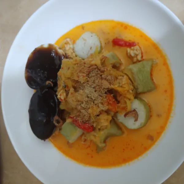 Tata irisan lontong di piring, siram dengan sayur manisa. Tambahkan telur petis dan beri taburan bawang goreng dan koya kelapa. Sajikan dengan kerupuk emping.