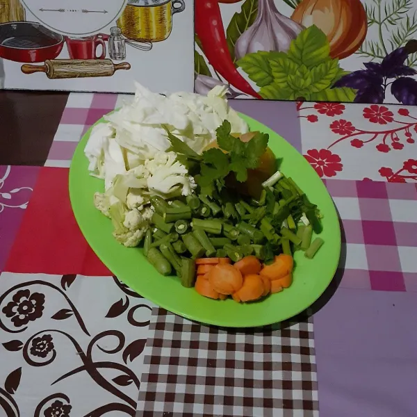 Iris semua bahan sayur dan daun bawang. Simpulkan seledri.