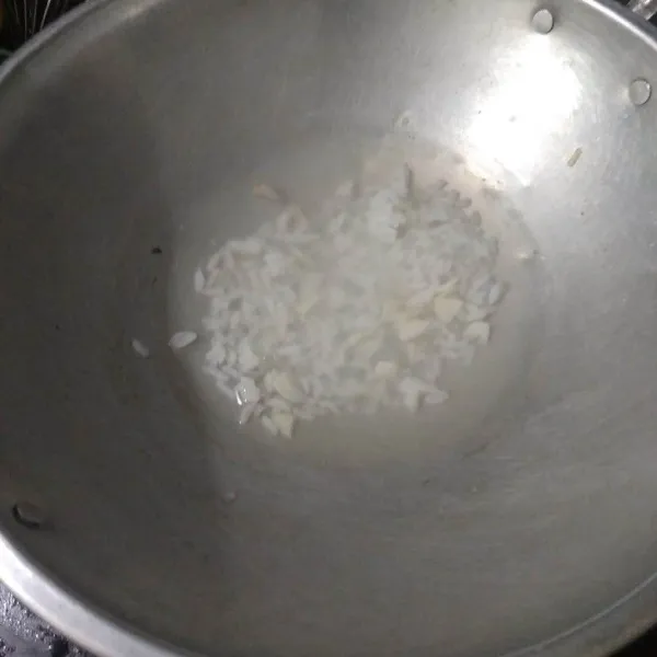 Didihkan air lalu masukkan nasi, bawang merah, dan bawang putih yang sudah dicincang. Masak hingga air berkurang setengahnya.