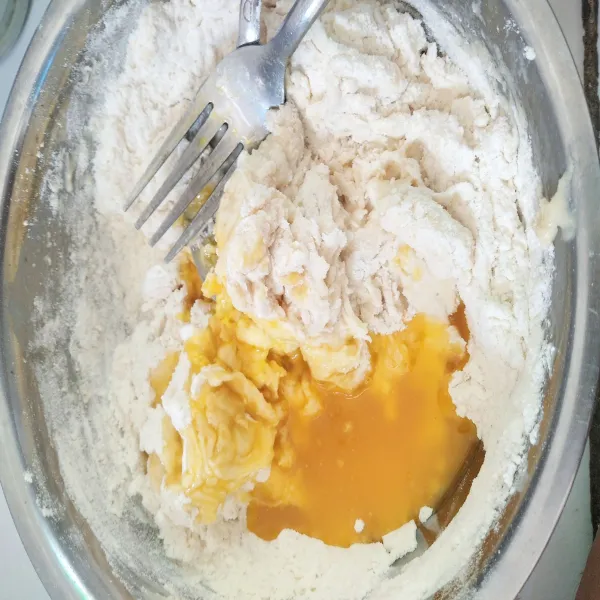 Kemudian tambahkan 100 ml air dan margarin. Campur dengan menggunakan sendok dan garpu hingga rata dan tidak perlu di banting-banting.