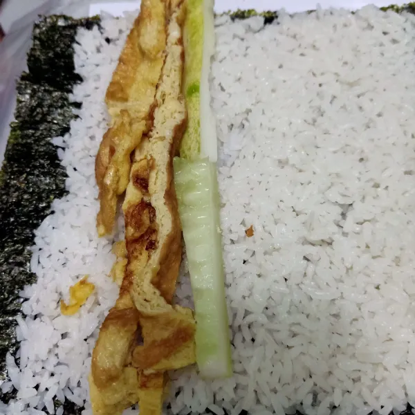 Cuci bersih mentimun lalu potong memanjang dan buang bijinya. Tata di pinggir telur dadar.