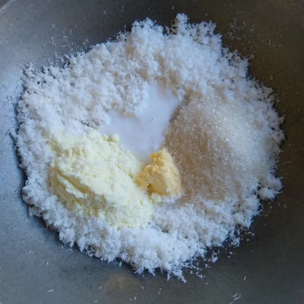 Tambahkan gula pasir, susu bubuk, margarin, dan santan kental. Aduk-aduk sampai margarin meleleh, gula terkaramelisasi sempurna, dan semua bahan menyatu dengan kelapa parut. Angkat.