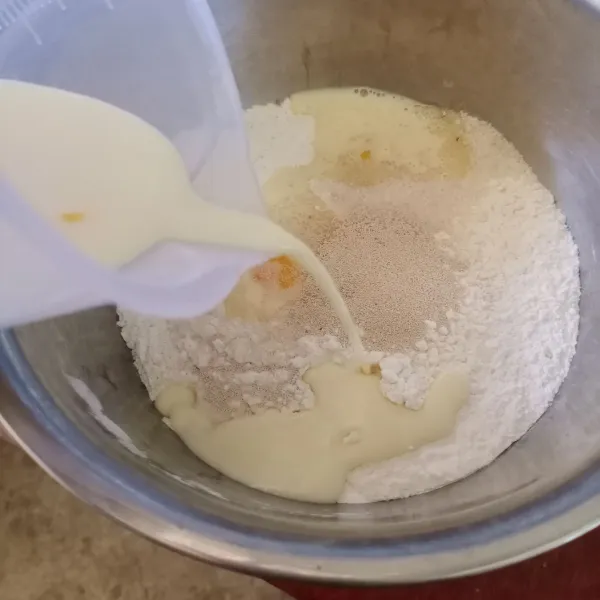 Masukkan terigu, gula, ragi, dan campuran telur dan susu ke dalam wadah.
