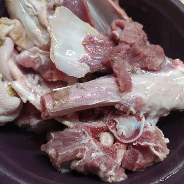 Cuci bersih daging, jeroan dan tulang kambing. Potong dadu daging dan jeroan.