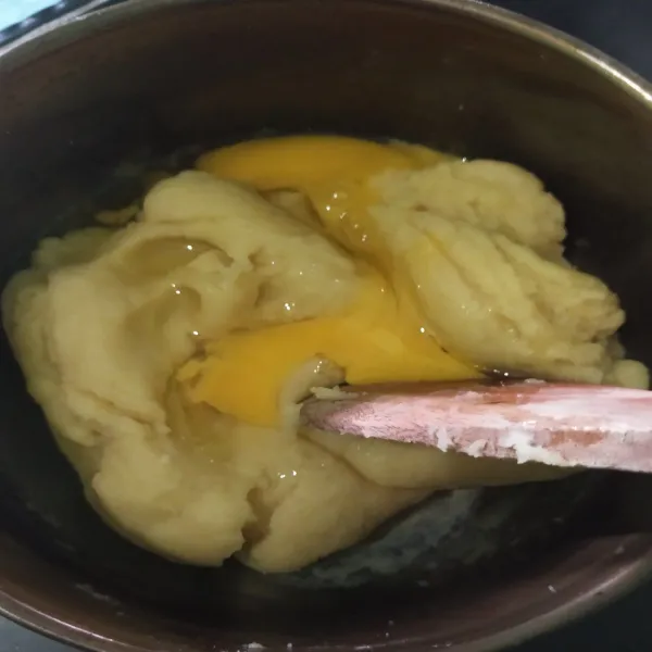 Setelah adonan dingin, tambahkan satu butir telur, aduk hingga tercampur rata.