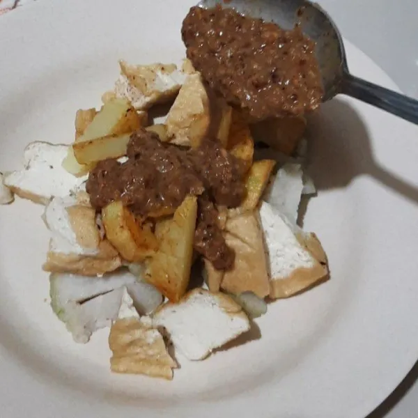 Penyajian : potong-potong tahu dan kentang lalu siram bumbu kemudian tabur tauge pendek.