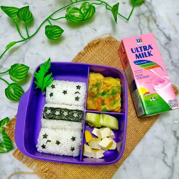 Siapkan nori kemudian gunting bentuk bintang atau hias sesuai selera. Taruh di atas nasi, lalu tambahkan dengan susu kesukaan anak. Bento siap disajikan untuk anak tercinta.