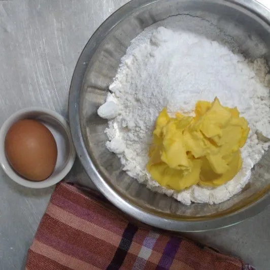 Buat bahan crust terlebih dahulu dengan campurkan tepung terigu, gula halus, dan margarin. Aduk hingga tercampur rata bergerindil, kemudian masukkan kuning telur, campur hingga setengah kalis.