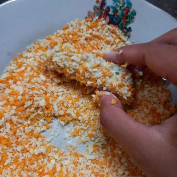 Masukkan potongan nasi pada adonan tepung kemudian gulung di tepung panir.