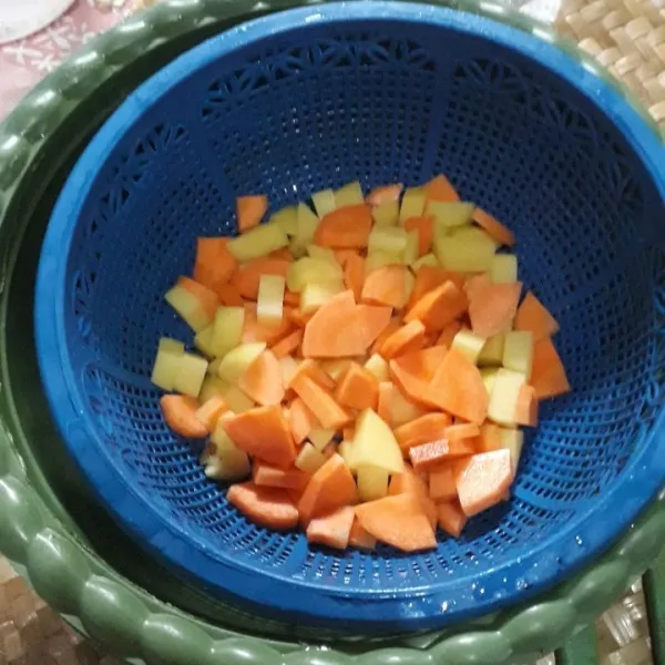 Potong-potong kentang dan wortel lalu cuci hingga bersih dan tiriskan.