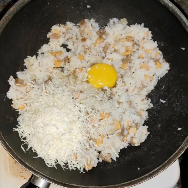Tambahkan keju parut cheddar dan telur .