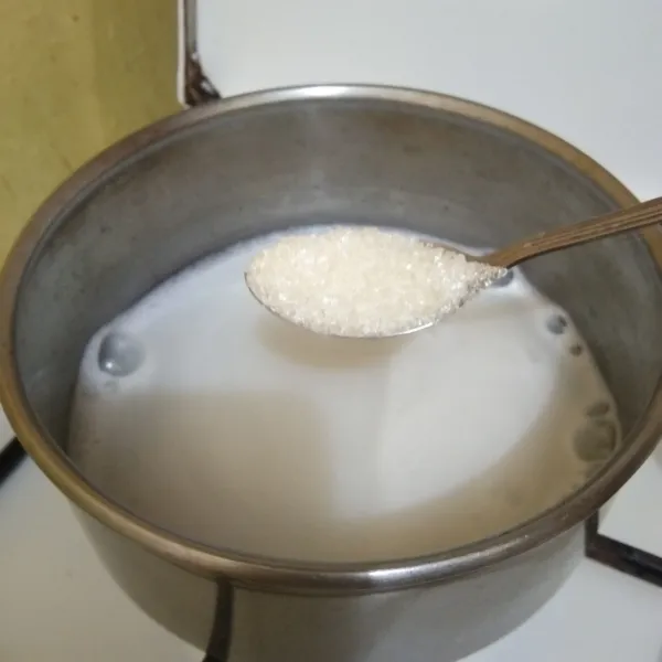 Didihkan susu cair dengan api kecil, tambahkan gula pasir. Aduk rata hingga gula larut.