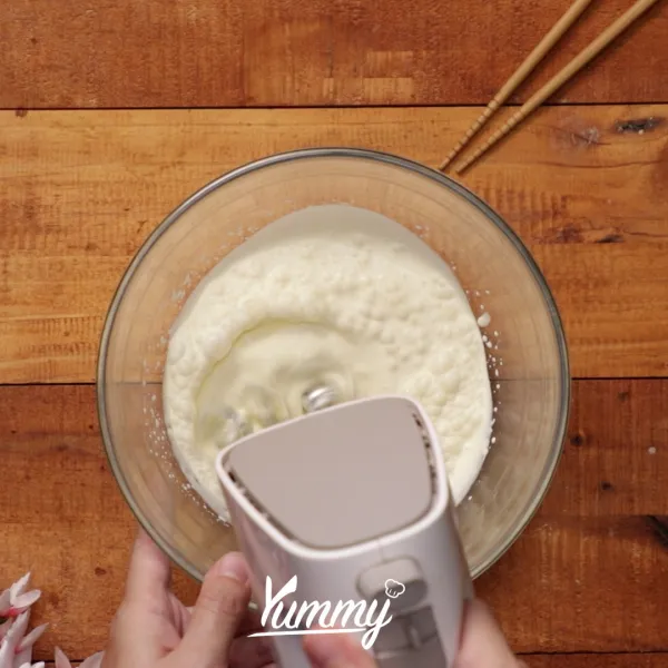 Kocok whipping cream hingga kaku dengan bantuan mixer.