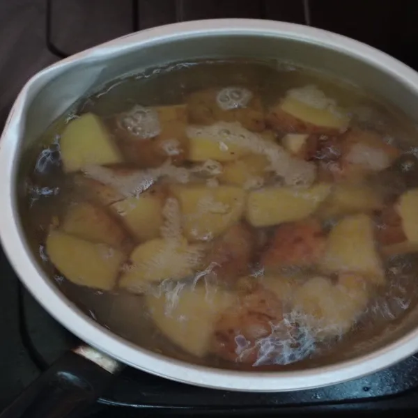 Potong kentang lalu rebus hingga cukup empuk, angkat serta tiriskan. Kupas kulitnya dan haluskan dengan garpu.