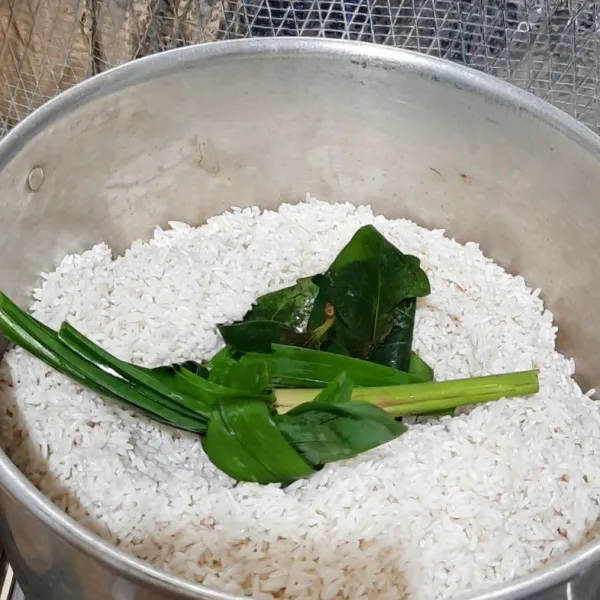 Siapkan kukusan madak airnya hingga mendidih lalu masukkan beras. Tambahkan daun salam, daun pandan dan serai. Masak selama 15 menit.